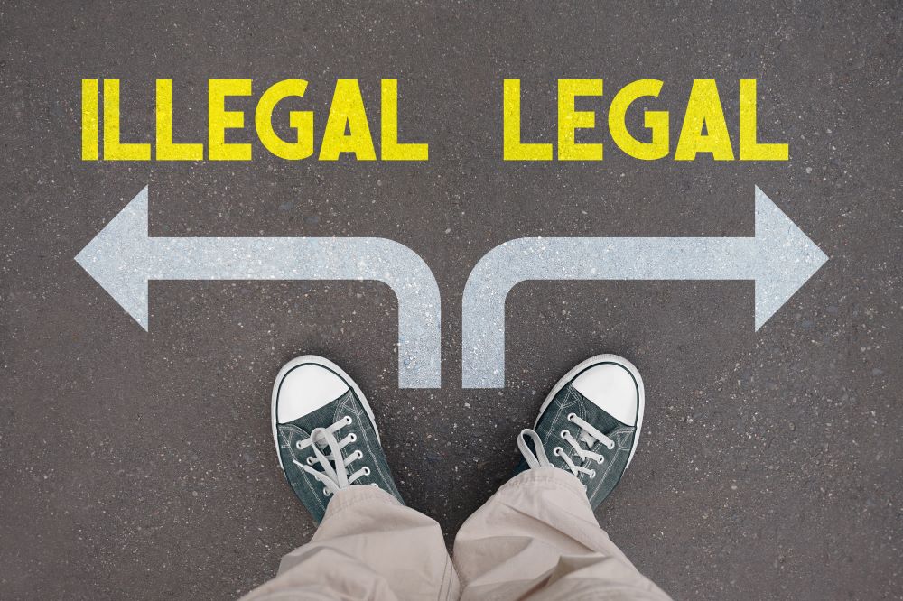 A fork in the road with 2 arrows one is illegal and the other legal indicating the patchwork of kratom legality across states in the USA