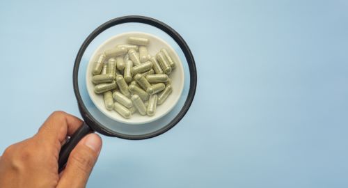 Examining kratom capsules under a magnifying glass