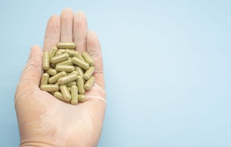 man holding capsules in hand