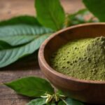 Dark red and green kratom in bowl surrounded by leaves