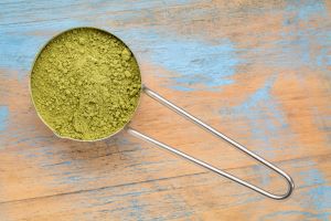 Kratom powder in a metal dosing spoon